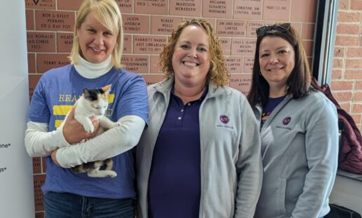 Three women, one holding a cat